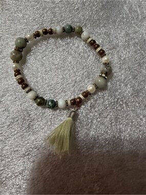 Green and White Beaded Stretch Bracelet with Tassel and Gold Accents